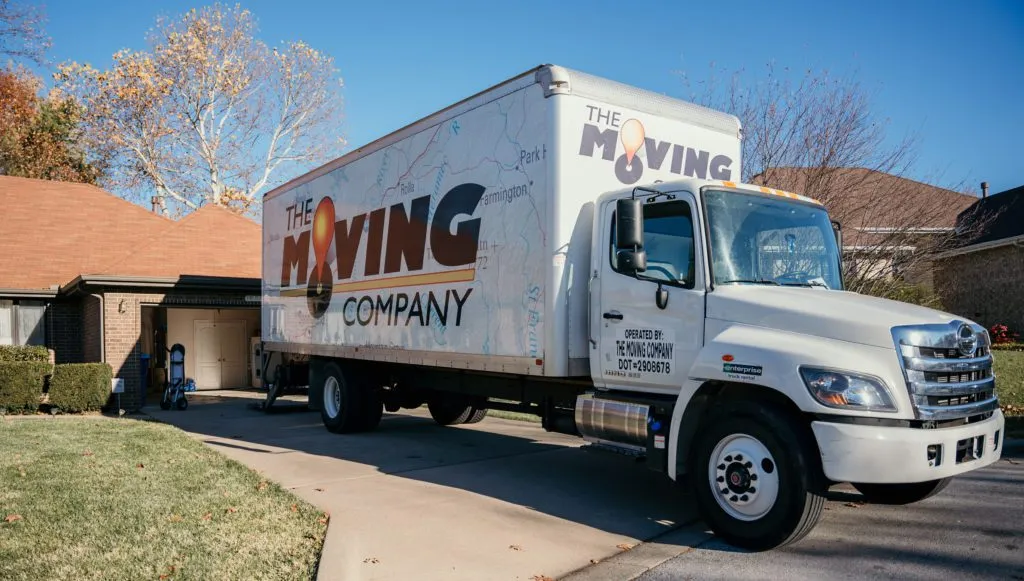 The Moving Company truck parked in front of a family's home